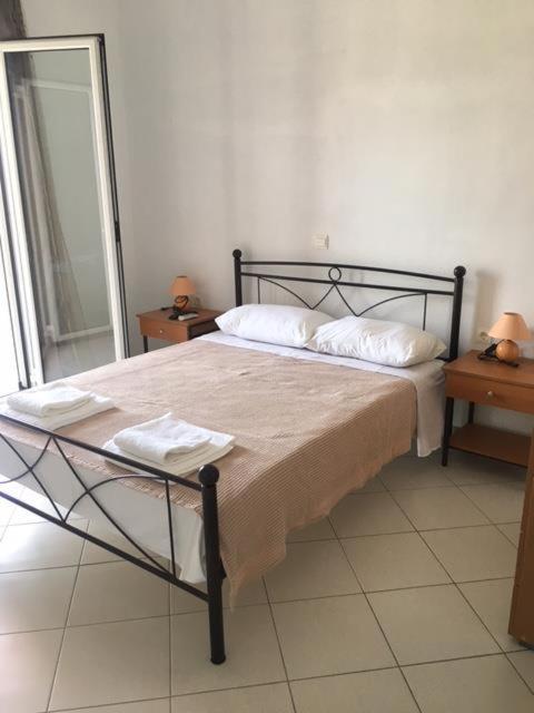 a bed in a bedroom with two tables and a mirror at Pefki Apartment 6 in Artemísion