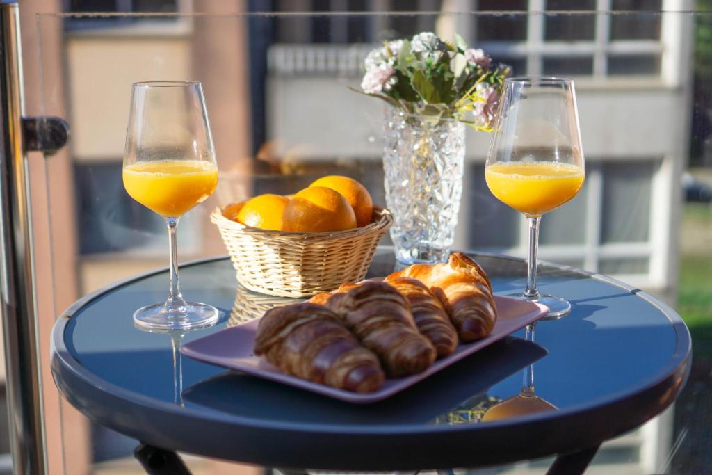 a table with two glasses of orange juice and croissants at ÁTICO MIRADOR Costa Da Morte in Ponteceso