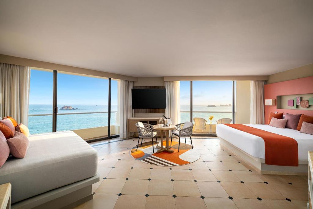 a hotel room with a bed and a view of the ocean at Sunscape Dorado Pacifico Ixtapa Resort & Spa- All Inclusive in Ixtapa