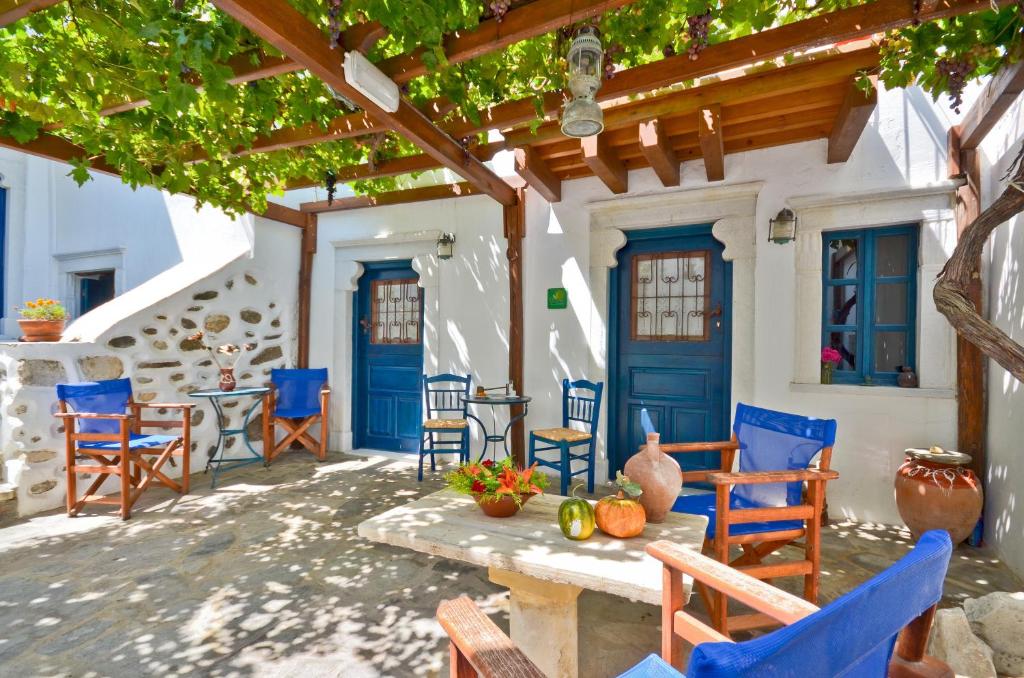 a patio with blue chairs and a table in front of a house at Venetiko Apartments in Naxos Chora