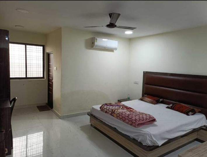 a bedroom with a bed and a ceiling fan at Rajwada Palace and Marriage Garden in Saipur