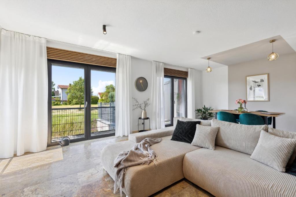 a living room with a couch and large windows at Ferienhaus-Terrassen-Parkplatz in Coburg