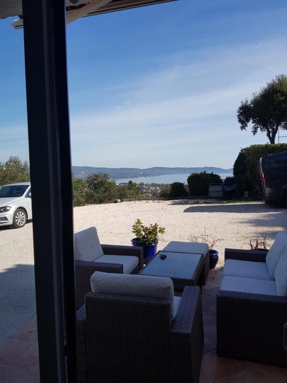d'une terrasse avec des chaises et des tables et une vue sur la plage. dans l'établissement Vue mer exceptionnelle, à Cavalaire-sur-Mer