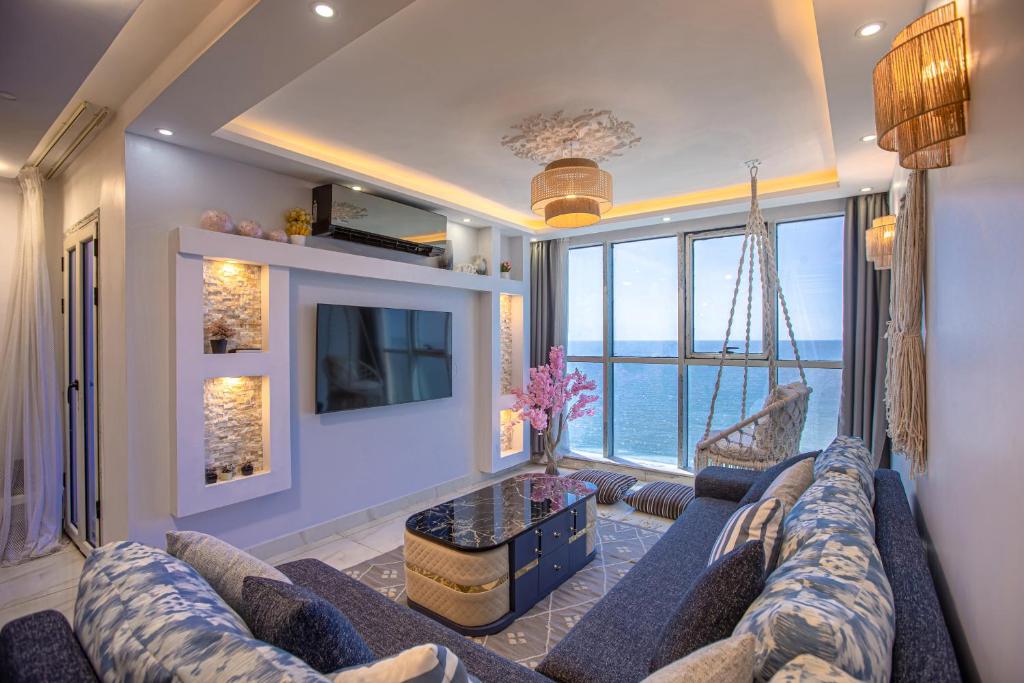 a living room with a blue couch and a large window at Skyline Premium Properties in Alexandria