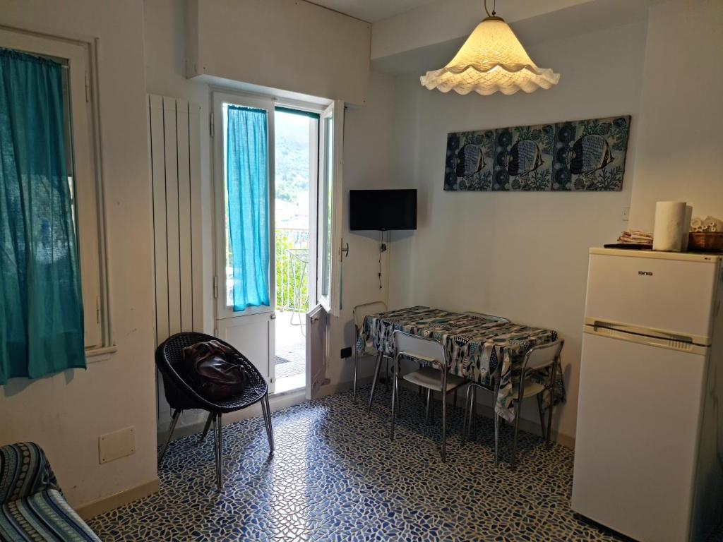 a kitchen with a table and a refrigerator and a window at Bilocale vicinissimo 50m mare in Levanto