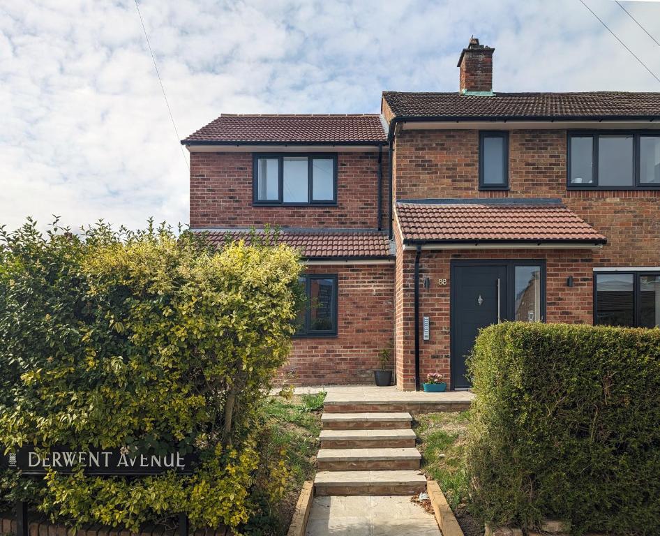 a brick house with a staircase in front of it at Derwent Avenue self-contained apartments in Headington in Oxford