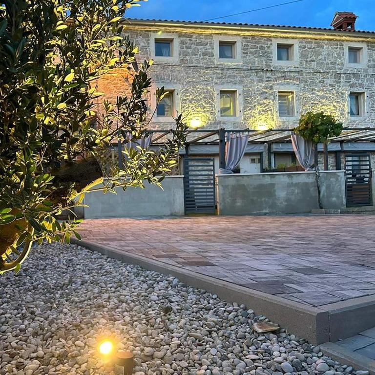 a large stone building with a stone courtyard at Villa Vega in Višnjan