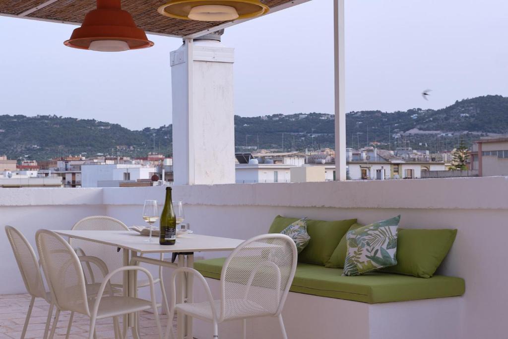- Balcón con mesa y sillas y botella de vino en L'Arco delle Fogge - Suite con Terrazzo Esclusivo, en Fasano