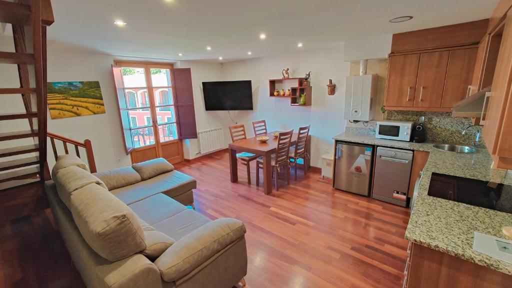 a living room with a couch and a kitchen with a table at Cabirol in Camprodon