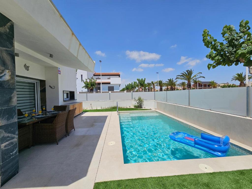 a swimming pool in the backyard of a house at Holiday Home KyDo - Heated Pool - Roof Terrace - San Pedro del Pinatar in San Pedro del Pinatar