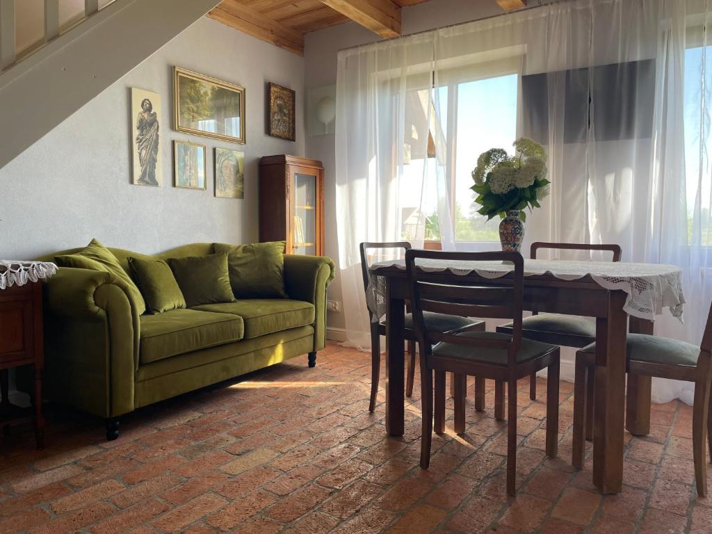 a living room with a green couch and a table at Drewniana Osada in Gołdap