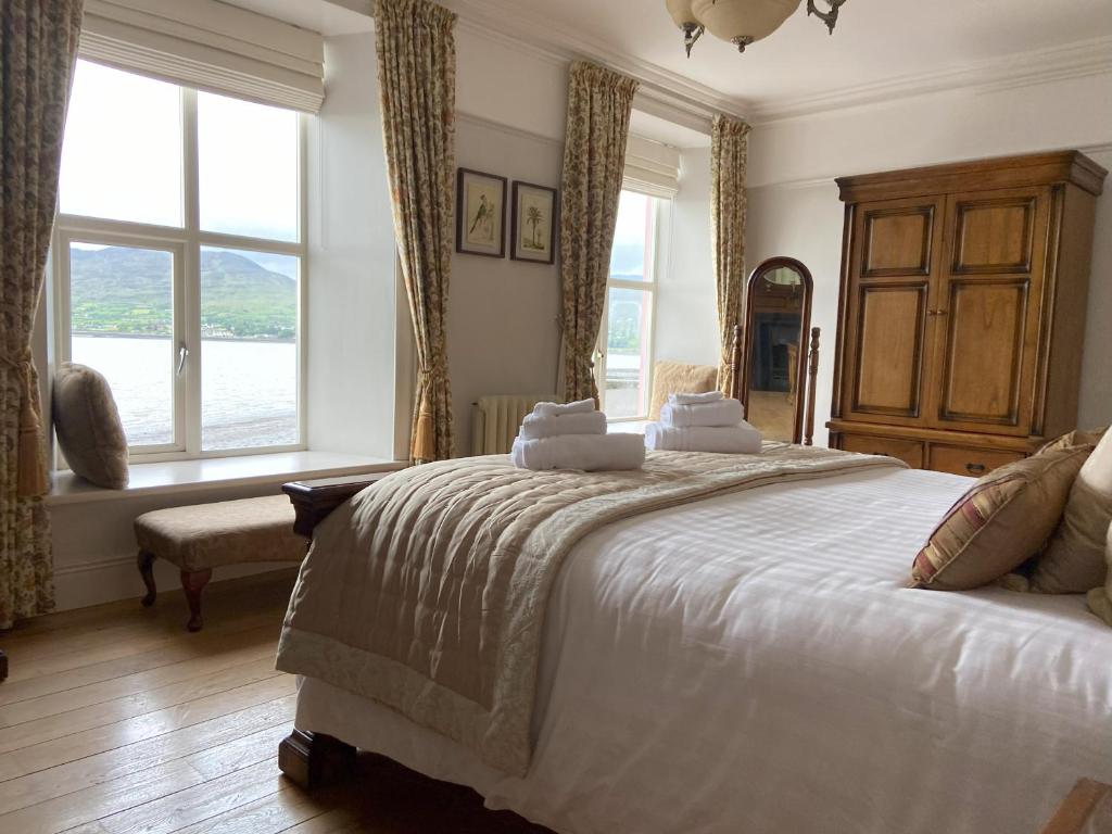 sypialnia z dużym białym łóżkiem i oknami w obiekcie Dolly's Cottage w mieście Warrenpoint