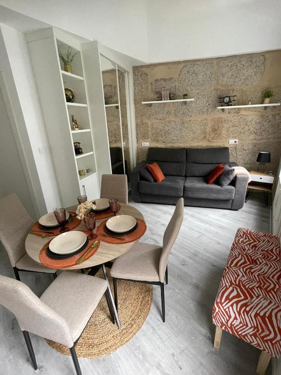 a living room with a table and chairs and a couch at Apartamentos SARABIA DARRIBA in Ourense