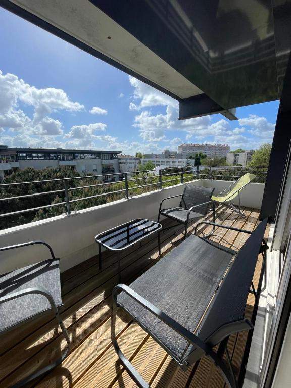 un balcon avec trois chaises et un banc dessus dans l'établissement T4 Chartrons Ravezies, à Bordeaux