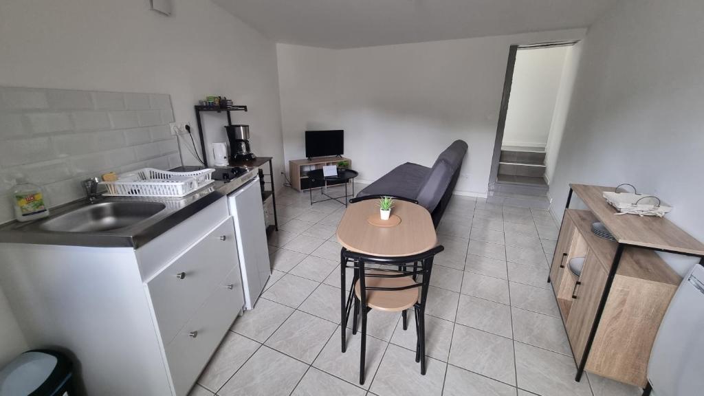 une petite cuisine avec une petite table et un évier dans l'établissement T2 37m2 proche Ker Lann Parc expo Aéroport, à Lassy
