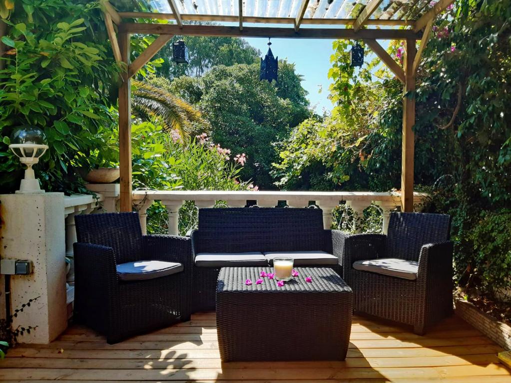 a patio with chairs and a table and a pergola at Romantic house Golfe Juan in Vallauris