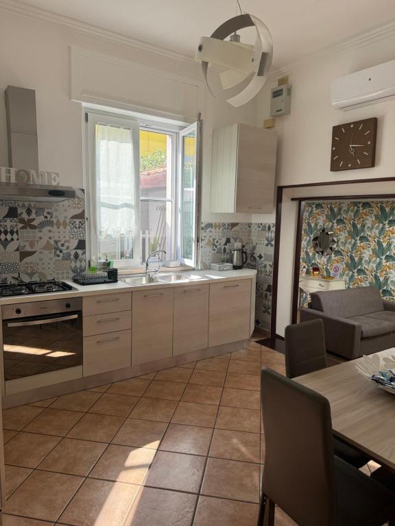 kuchnia z białymi szafkami, stołem i zlewem w obiekcie Gioviale House Pescara w mieście Pescara