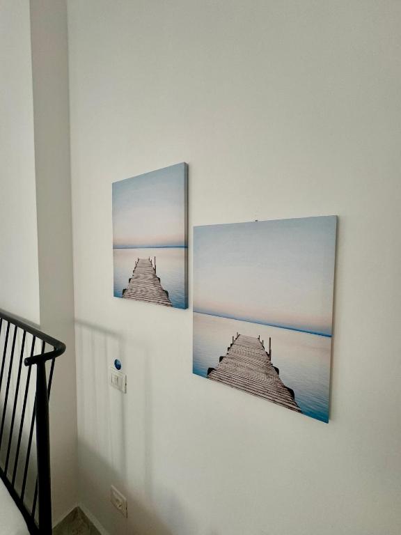 zwei Bilder hängen an einer Wand in einem Raum in der Unterkunft Comfy Blue Sarande in Sarandë