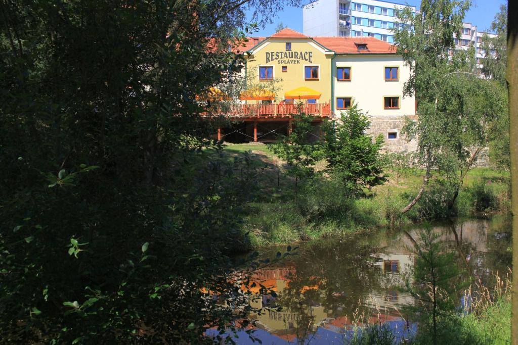 un edificio sentado junto a un cuerpo de agua en Hotel s restaurací Splávek en Strakonice