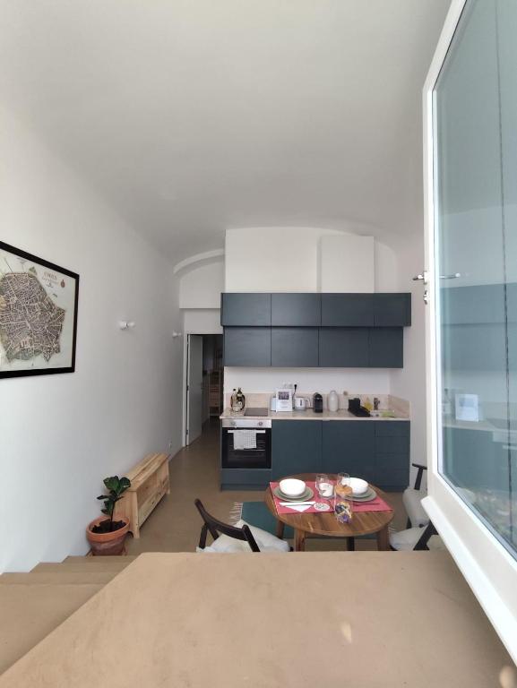 a living room with a table and a kitchen at Casa Pátio do Megué in Évora