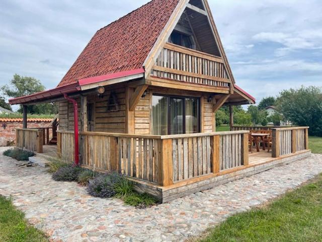 a large wooden cabin with a red roof at Auci Guest house 1 in Liepāja