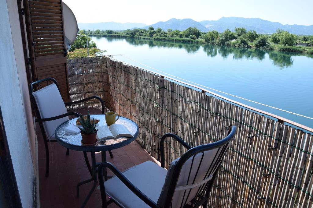 a table and chairs on a balcony with a view of a river at Nonna Kate in Komin