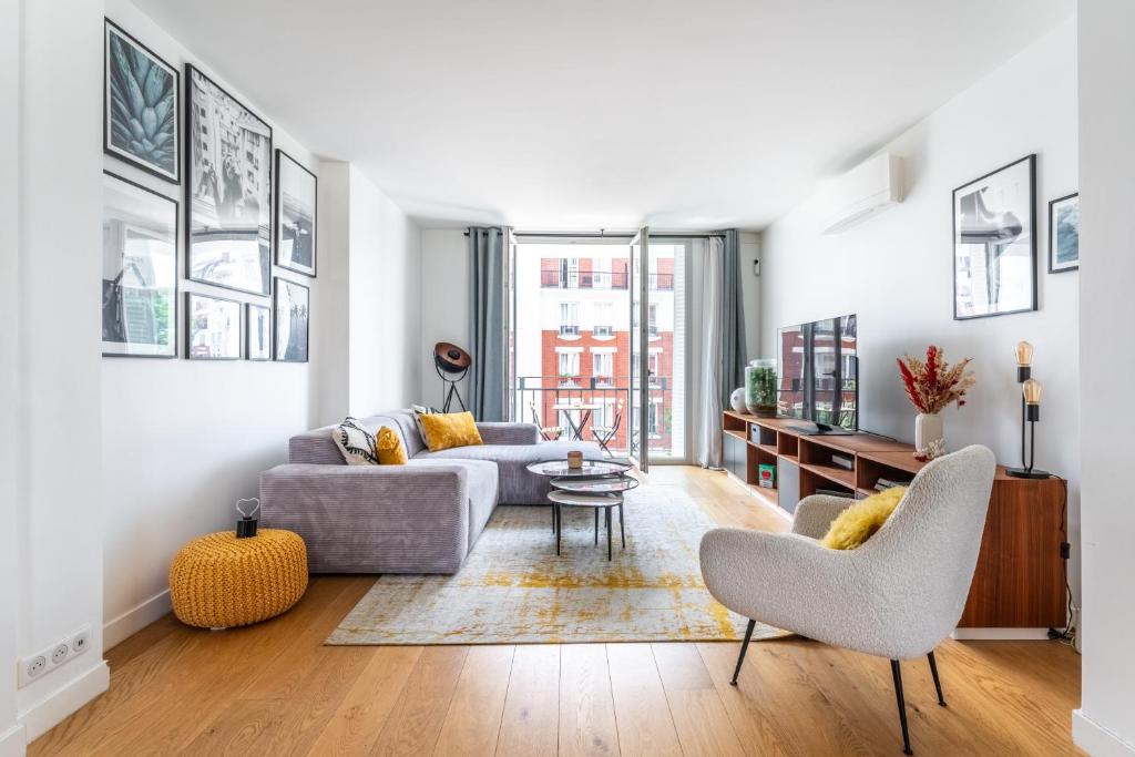 un salon avec un canapé, une table et des chaises dans l'établissement Paris 16 - Appartement entier - Chez Penny, à Paris