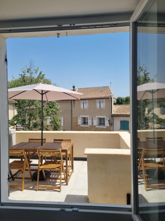 a view of a patio with tables and umbrellas at Maison de village avec terrasse in Grans