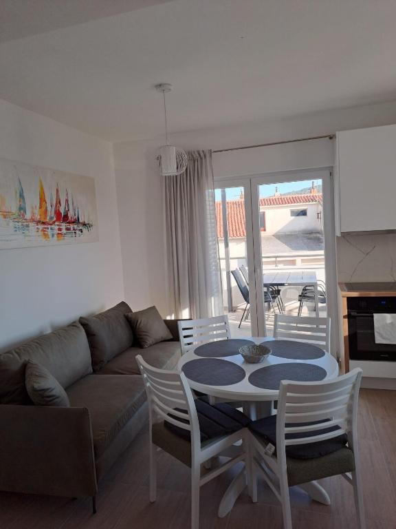 a living room with a couch and a table and chairs at Smokvica - NEW in Primošten