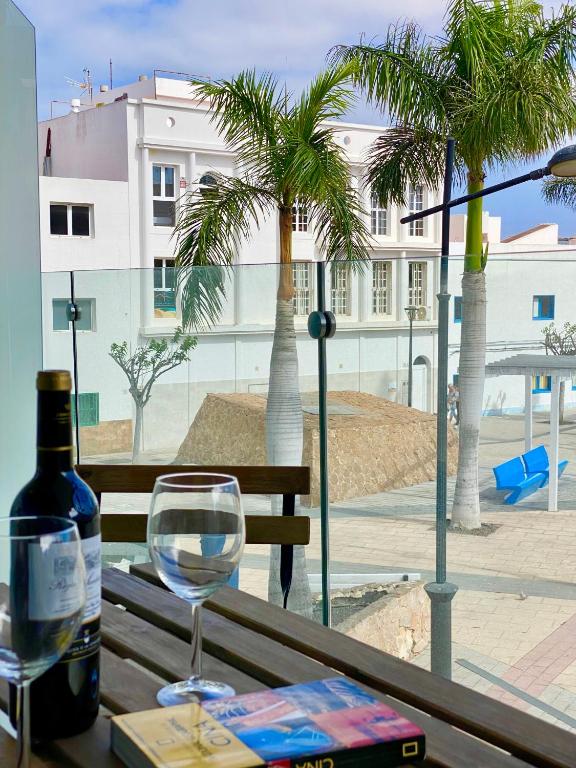a wine glass sitting on a table with a bottle of wine at Mulata Doré Suite in Corralejo