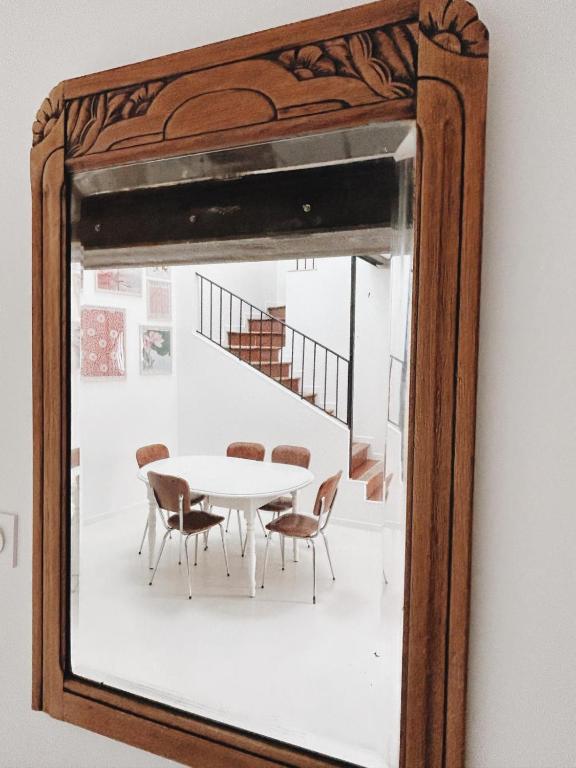 un miroir reflétant une table et des chaises dans la chambre dans l'établissement La Paca Majuca, à Saint-Thibéry