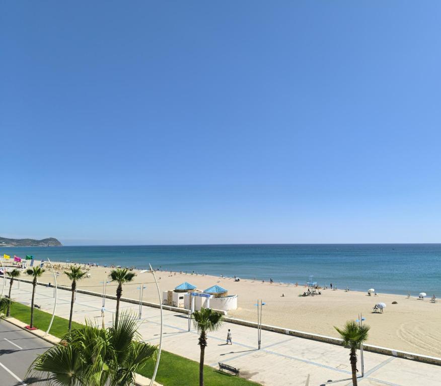 a view of a beach with people and the ocean at Appartement Spacieux et Accueillant avec Vue Panoramique sur la Mer in Martil
