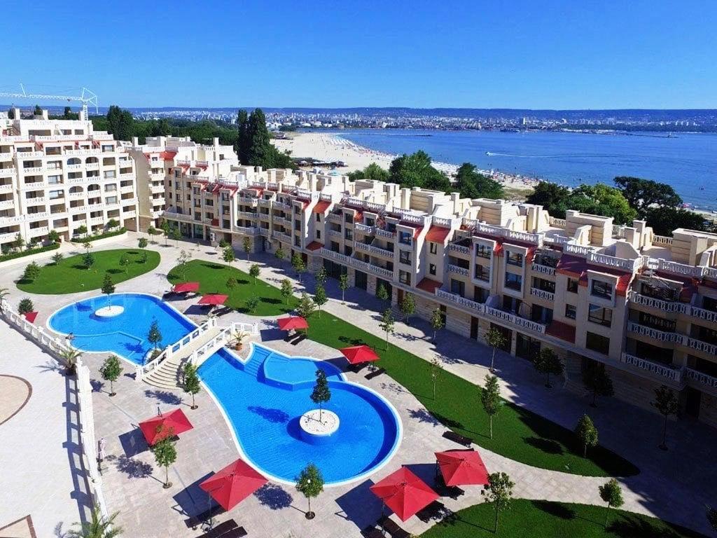 an aerial view of a resort with two pools and umbrellas at Sunrise Luxury Sauth Bay in Varna City