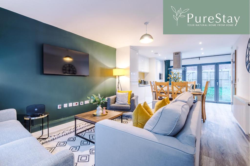 a living room with a couch and a dining room at Stunning Manchester House Sleeps 10 with Parking by PureStay - Short Stays & Accommodation in Manchester
