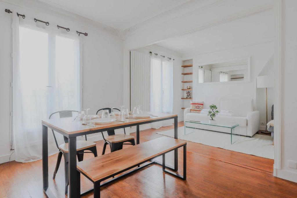 une salle à manger avec une table et des chaises et un salon dans l'établissement Peaceful apartment - 1BD- 4P - Montmartre, à Paris