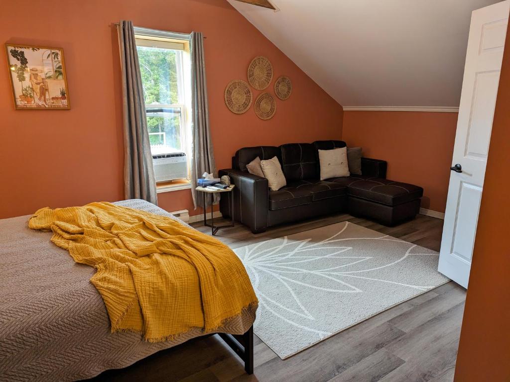 a bedroom with a bed and a couch at The Parrsboro Mansion Inn in Parrsboro