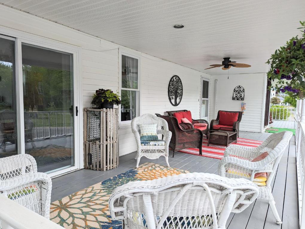 a porch with white wicker chairs and a couch at The Parrsboro Mansion Inn in Parrsboro