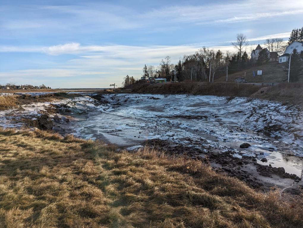 a river with snow on the side of a field at The Parrsboro Mansion Inn in Parrsboro