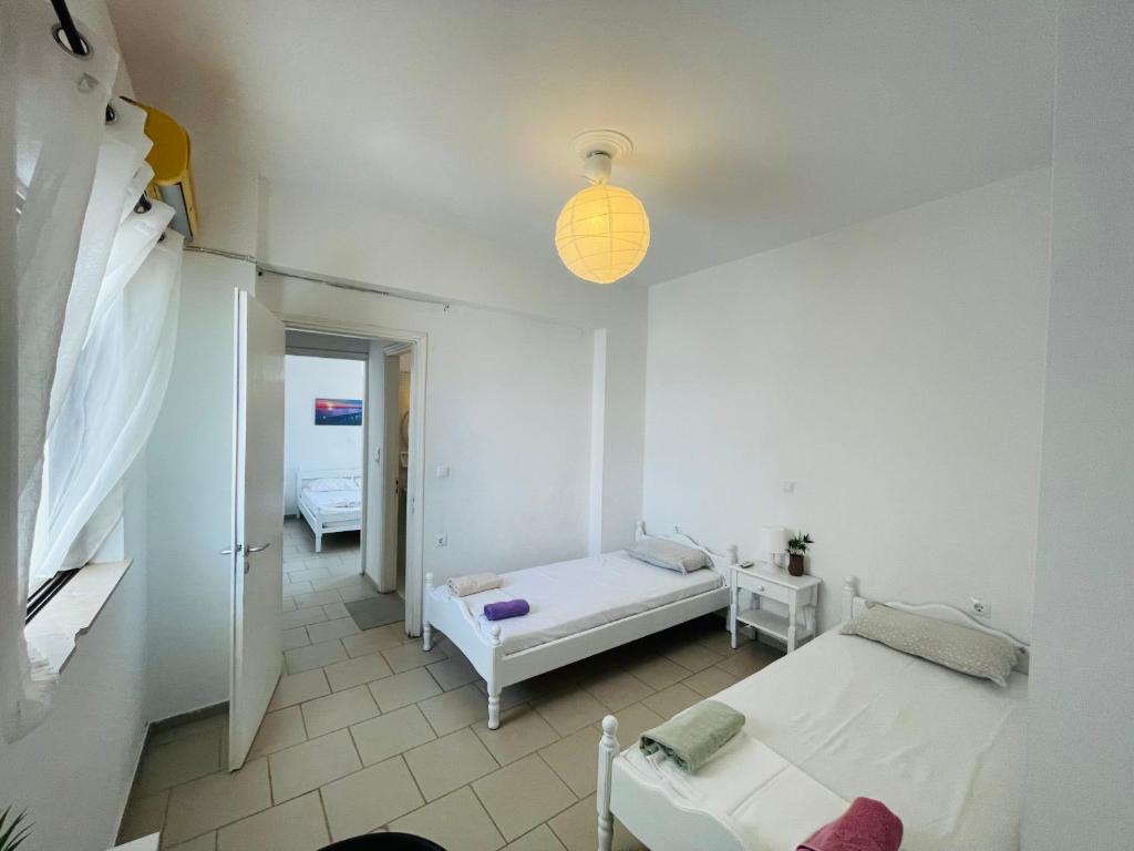 - une chambre avec 2 lits et un éclairage dans l'établissement Akrata v apartment, à Akrata