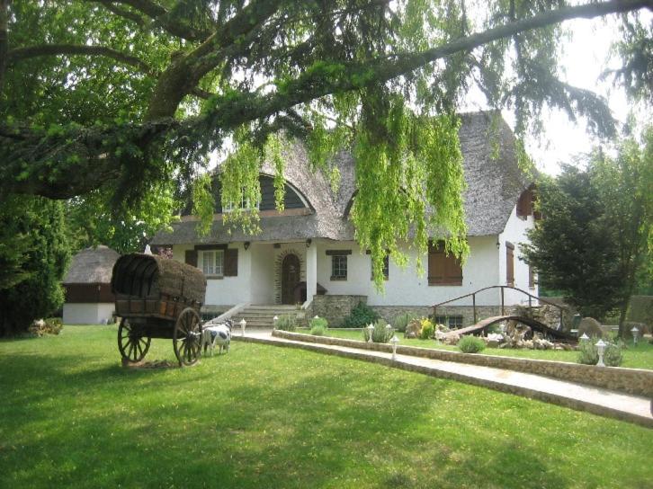 une calèche tirée par des chevaux devant une maison dans l'établissement La chaumière, à Rambouillet