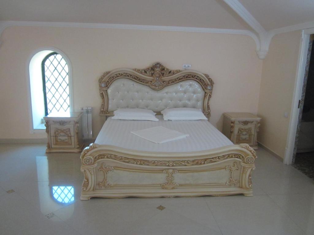 a bedroom with a large bed with a gold frame at Venezia Palazzo Hotel in Yerevan