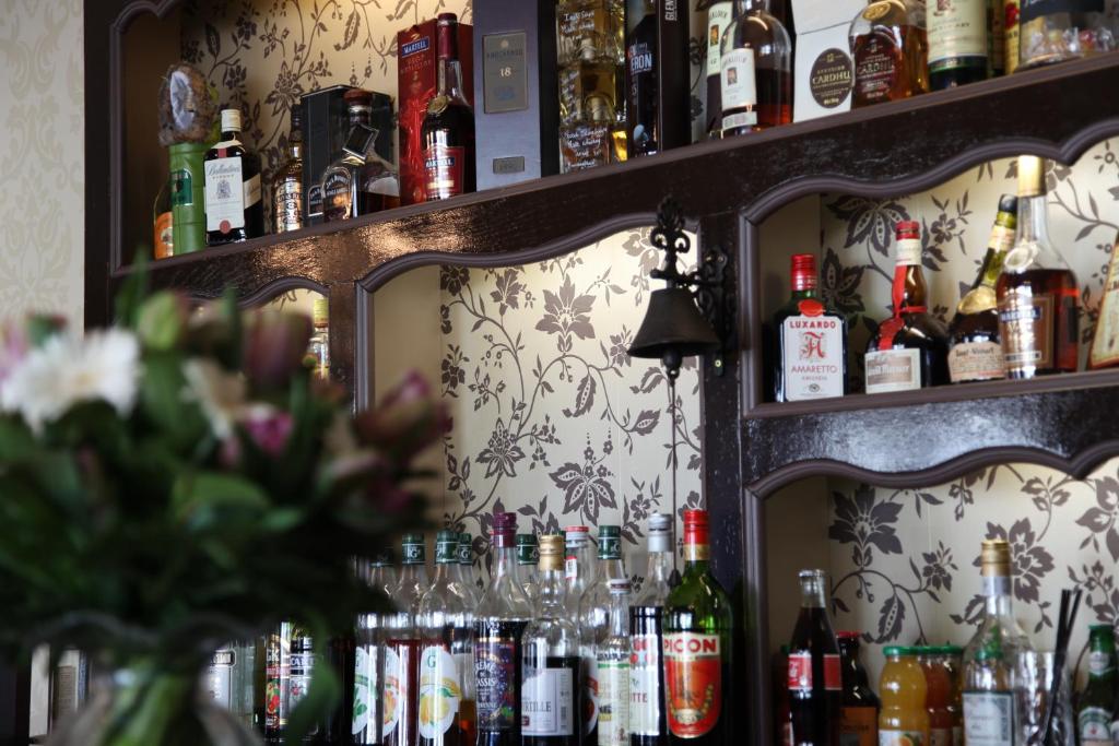 a bar with a bunch of bottles of alcohol at Logis Hotel Des Bains in Gérardmer