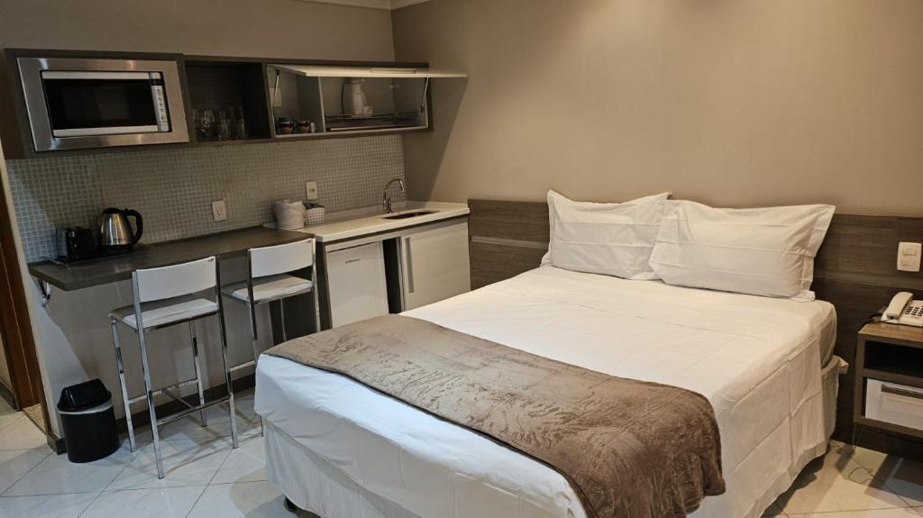 a small bedroom with a bed and a kitchen at Aeroporto Congonhas Hotel UH103 in Sao Paulo