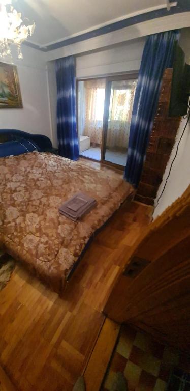 a bedroom with a large bed with a wooden floor at Apartament Ania&Maria in Băile Herculane