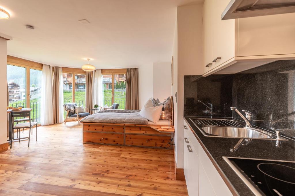 a kitchen with a bed in the middle of a room at Studio Haro in Zermatt