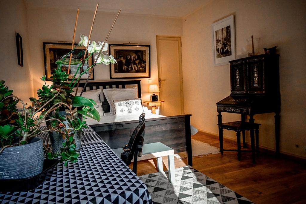 Cette chambre comprend un lit et une table avec un piano. dans l'établissement La vie de château à Orgeval - Chambre Feydeau, à Orgeval