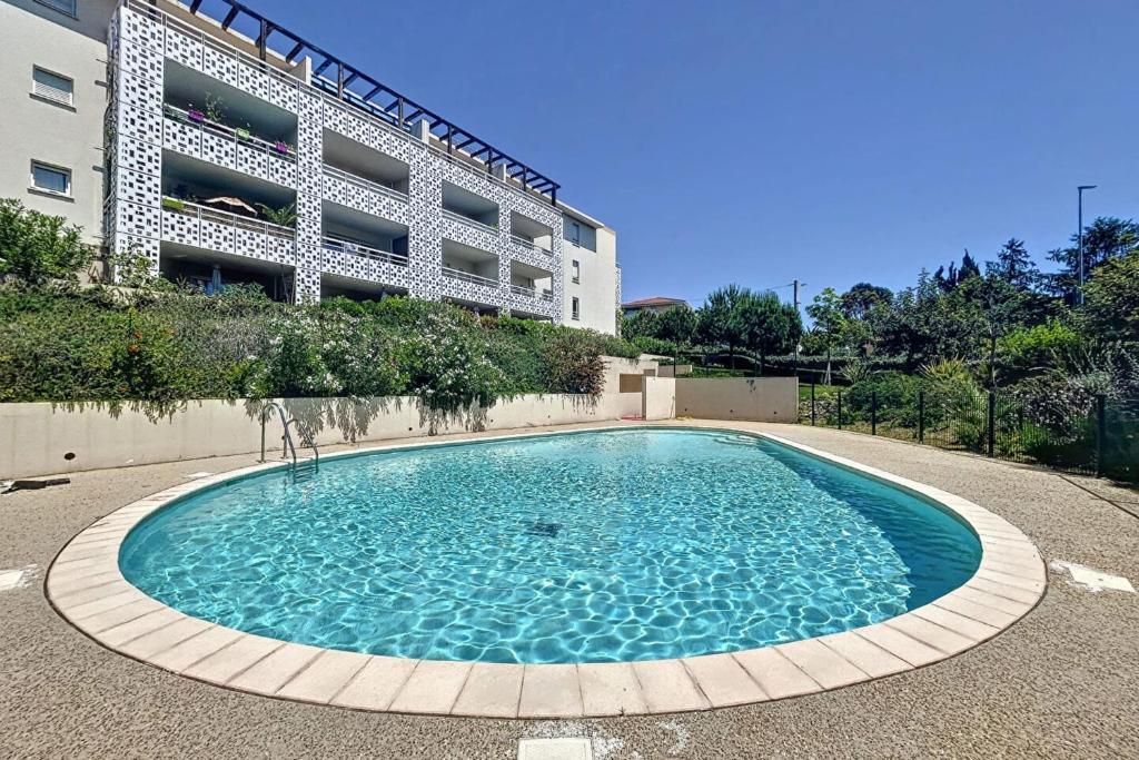 une grande piscine devant un immeuble dans l'établissement Family apartment 2 Rooms in Antibes, à Antibes