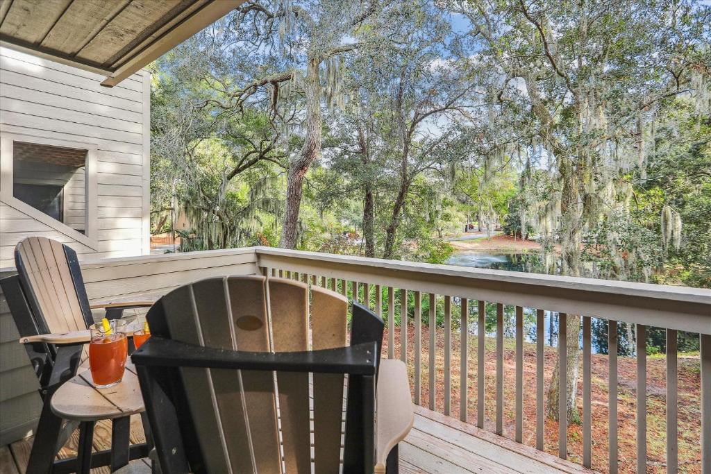 a porch with two chairs and a table on a balcony at 2319 Racquet Club in Hilton Head Island