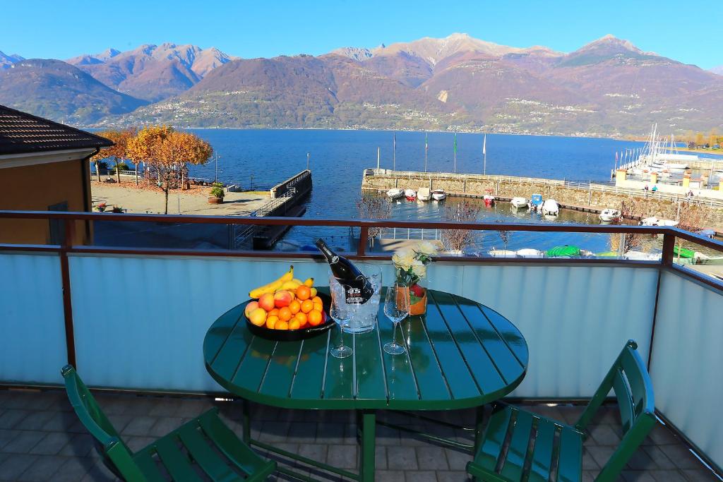 a table with a bowl of fruit on a balcony at The Lake Apartment in Colico