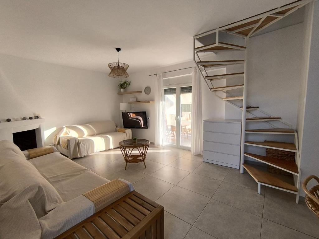 a living room with a couch and a spiral staircase at Kynthia's House in Kalyves Poligirou